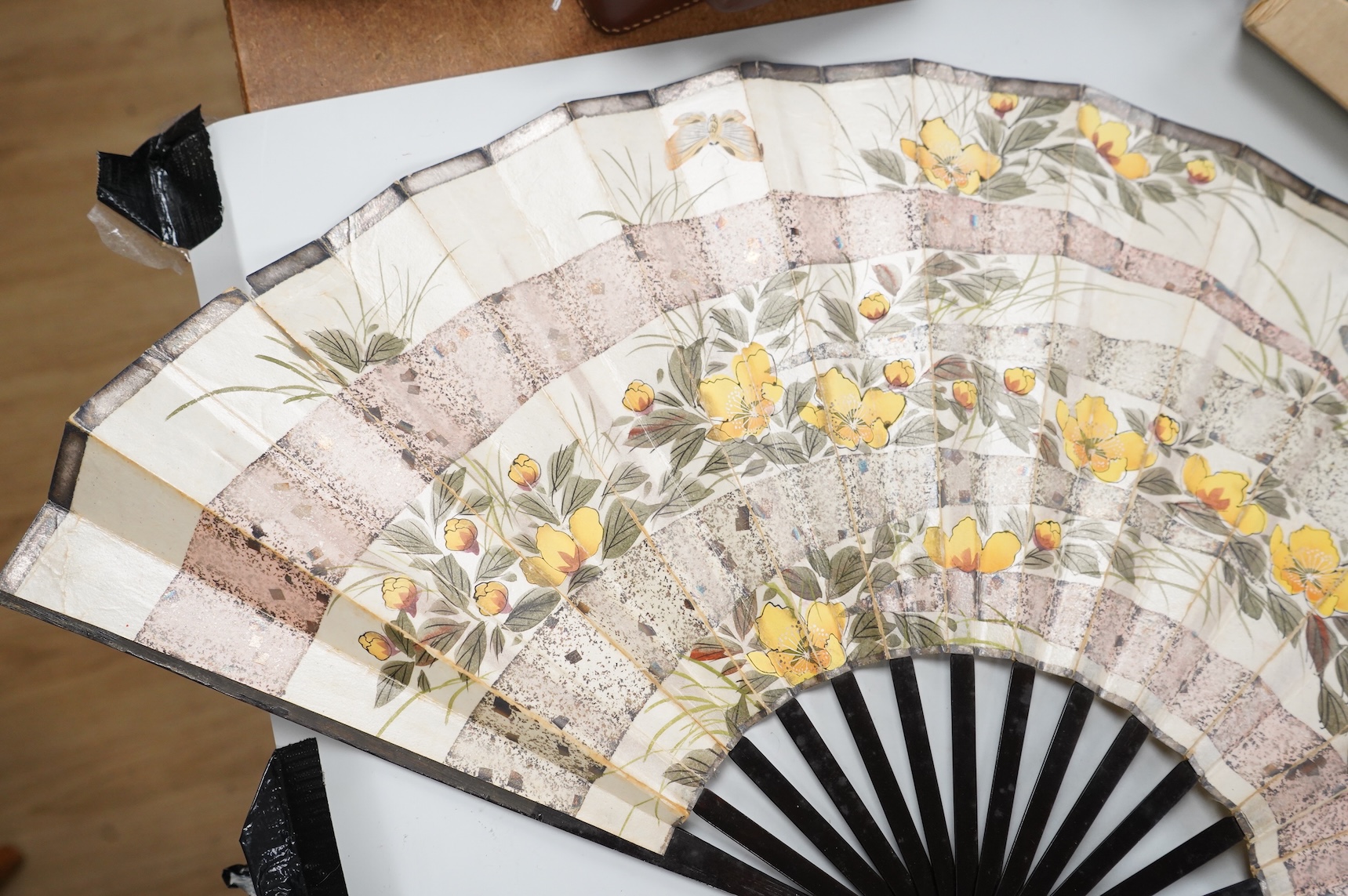 A gold mounted lace and hand painted fan and three others to include a lacquered example, one cased
